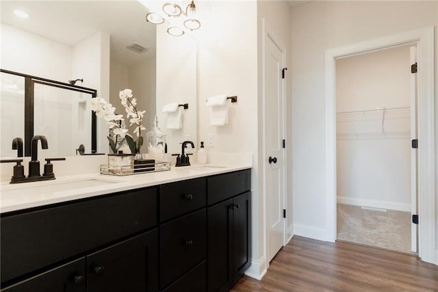 bathroom with wood-type flooring, vanity, and walk in shower