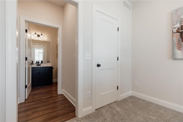 hallway with dark colored carpet