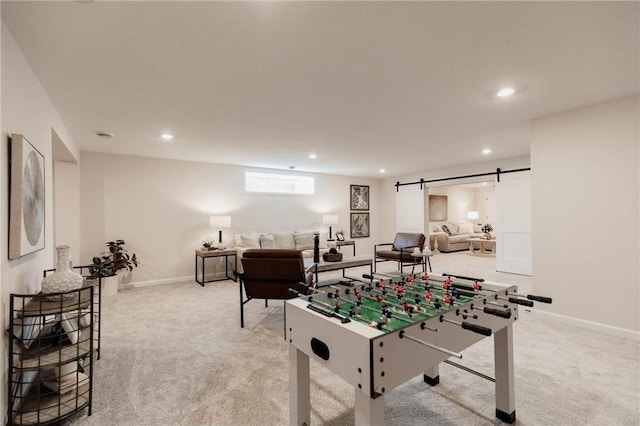 game room featuring a barn door and light carpet