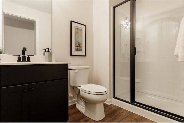 bathroom with toilet, vanity, an enclosed shower, and hardwood / wood-style flooring