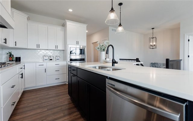 kitchen featuring pendant lighting, backsplash, sink, stainless steel appliances, and extractor fan