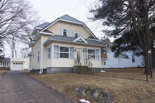 view of front of home featuring a garage and an outbuilding