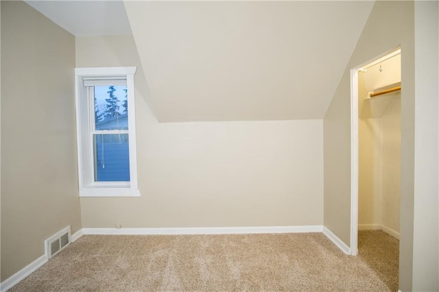 bonus room featuring light colored carpet and vaulted ceiling