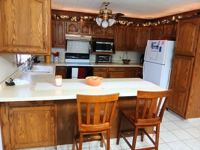 kitchen with sink, white appliances, light tile patterned flooring, kitchen peninsula, and backsplash