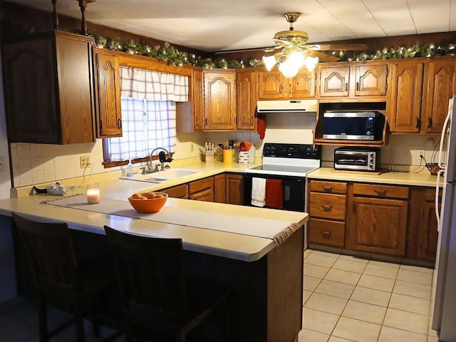 kitchen featuring white appliances, kitchen peninsula, light tile patterned flooring, ceiling fan, and sink