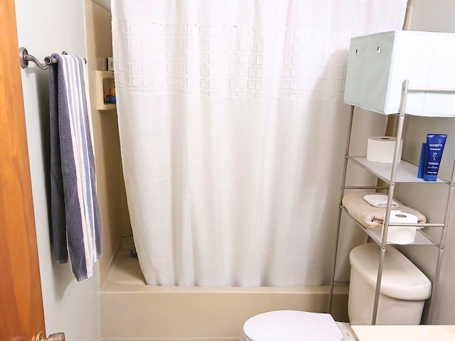 bathroom featuring toilet and shower / bath combo with shower curtain