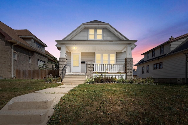 view of front of home with a lawn and a porch