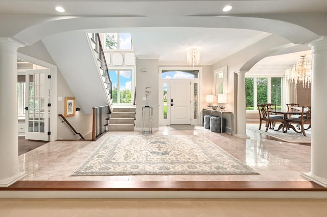 foyer entrance featuring ornamental molding and a chandelier