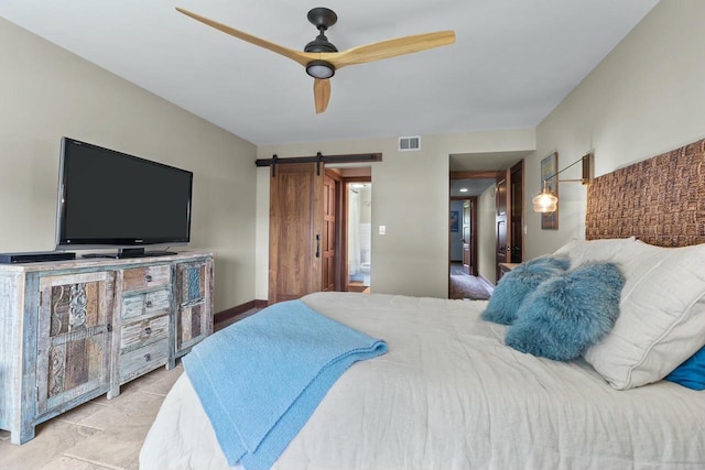 bedroom with a barn door and ceiling fan