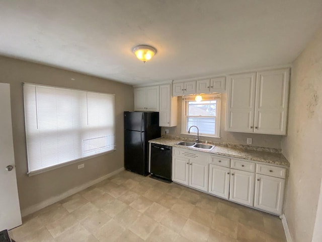 kitchen with black appliances, light stone countertops, white cabinetry, and sink