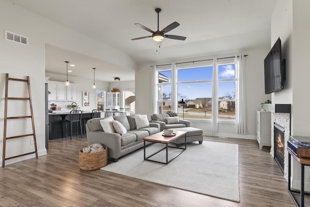 living room with a wealth of natural light, dark hardwood / wood-style flooring, and ceiling fan