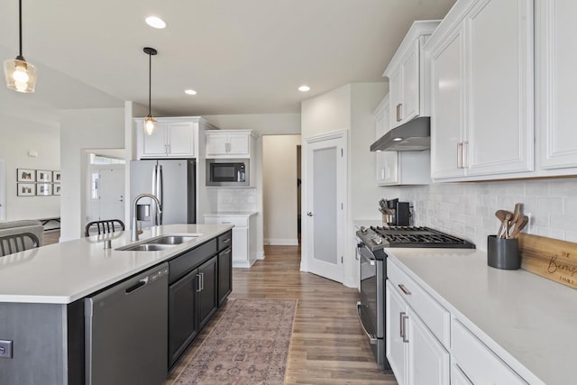 kitchen featuring sink, stainless steel appliances, pendant lighting, a center island with sink, and white cabinets