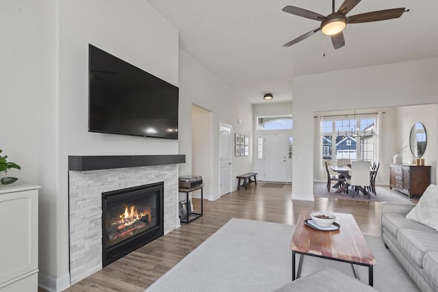 living room with ceiling fan, wood-type flooring, and a fireplace