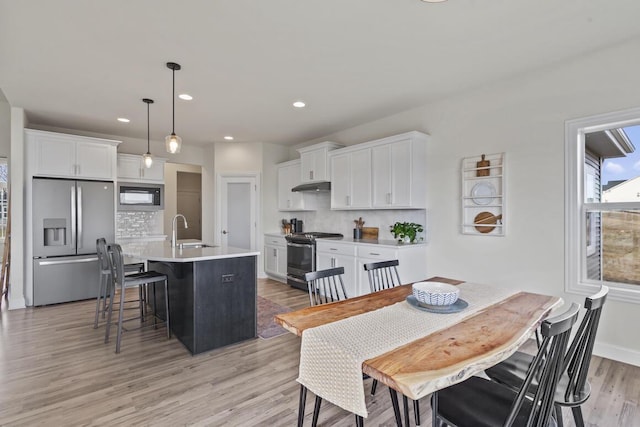 dining area featuring sink and light hardwood / wood-style flooring