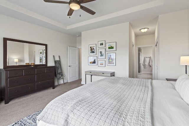 bedroom featuring ceiling fan, a raised ceiling, and light carpet