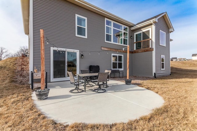 rear view of house featuring a lawn and a patio