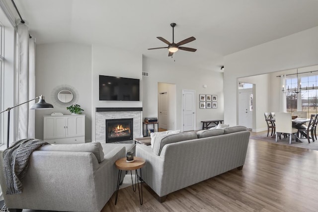 living room featuring hardwood / wood-style floors, a stone fireplace, and ceiling fan