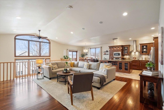 living room with dark hardwood / wood-style floors, vaulted ceiling, and ceiling fan