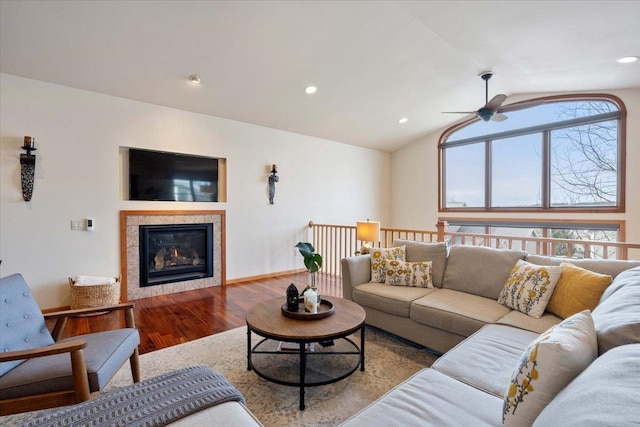 living room with light hardwood / wood-style floors, vaulted ceiling, and ceiling fan