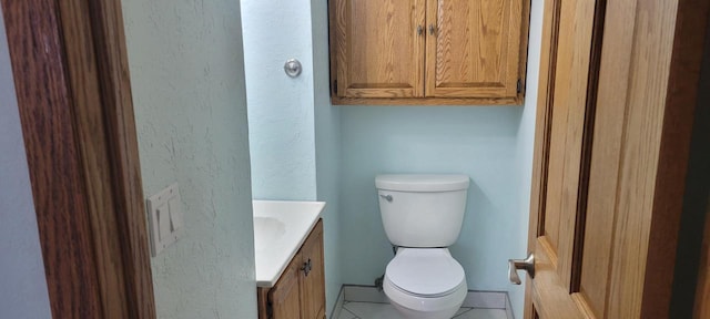 bathroom with tile patterned flooring, vanity, and toilet