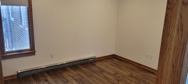 spare room featuring dark hardwood / wood-style flooring and baseboard heating