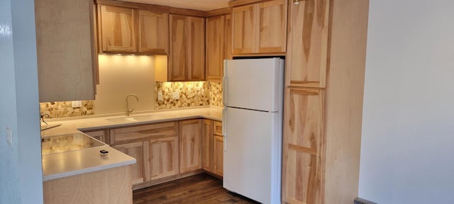 kitchen featuring light brown cabinetry, white refrigerator, backsplash, and sink