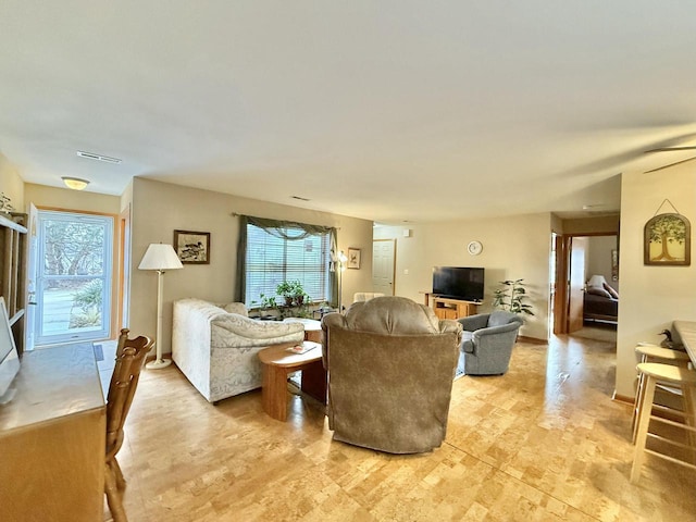 living room featuring plenty of natural light and ceiling fan