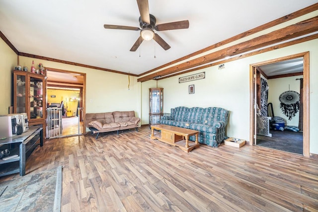 living room with ceiling fan, wood-type flooring, and crown molding