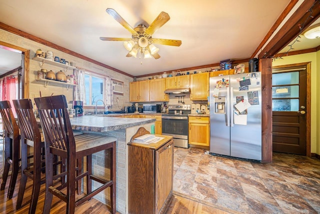 kitchen featuring ceiling fan, sink, a kitchen breakfast bar, crown molding, and appliances with stainless steel finishes