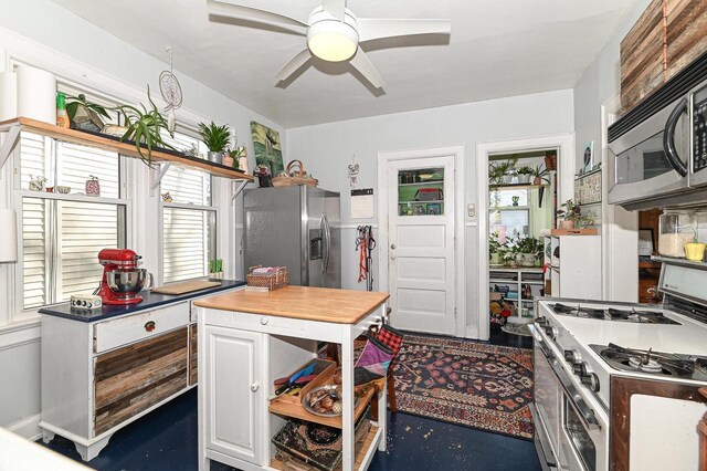 kitchen with ceiling fan, white cabinetry, and appliances with stainless steel finishes