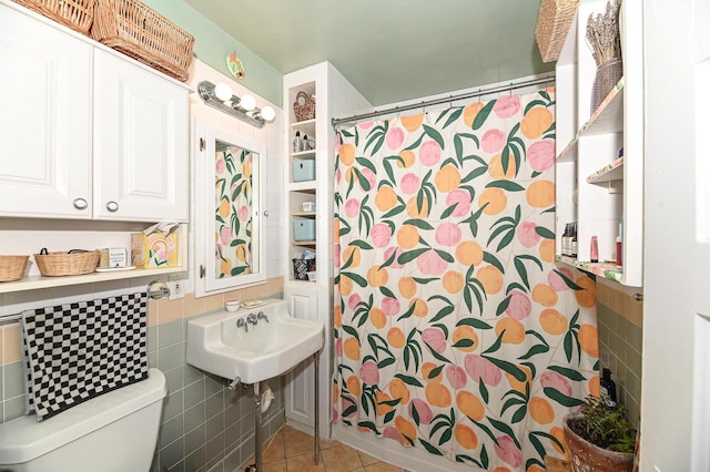 bathroom featuring tile patterned flooring, a shower with shower curtain, tile walls, and toilet