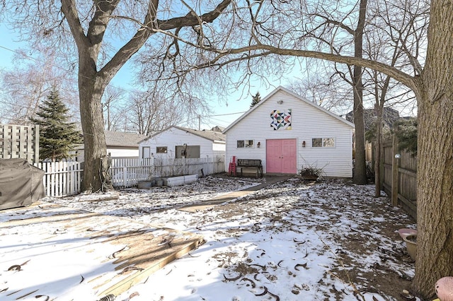 snow covered property featuring an outbuilding