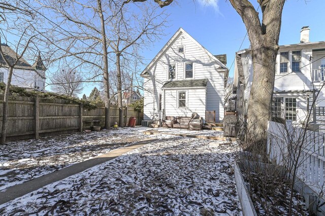 snow covered rear of property featuring cooling unit