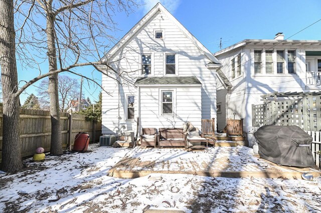 snow covered rear of property with cooling unit