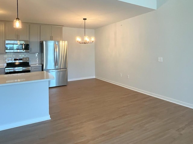 kitchen featuring decorative backsplash, an inviting chandelier, decorative light fixtures, and appliances with stainless steel finishes