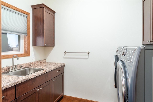 clothes washing area with cabinets, independent washer and dryer, and sink