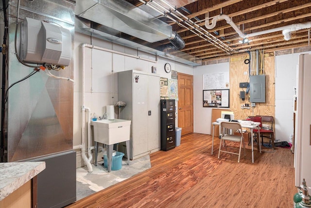 basement with electric panel and hardwood / wood-style flooring