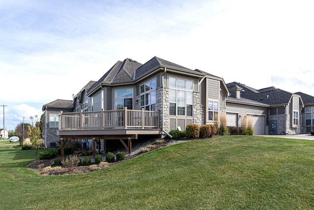 view of front of home with a wooden deck, a front yard, and a garage