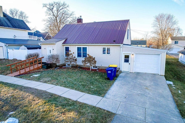 rear view of property with a garage and a lawn