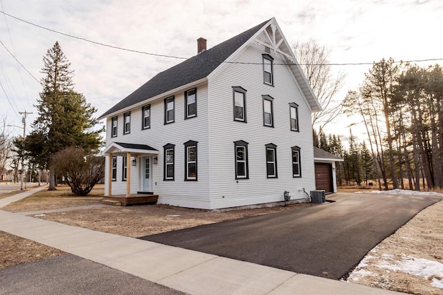 view of side of property featuring central AC unit and a garage