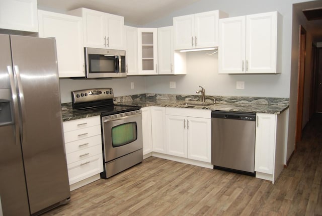 kitchen featuring dark stone counters, white cabinetry, sink, and stainless steel appliances