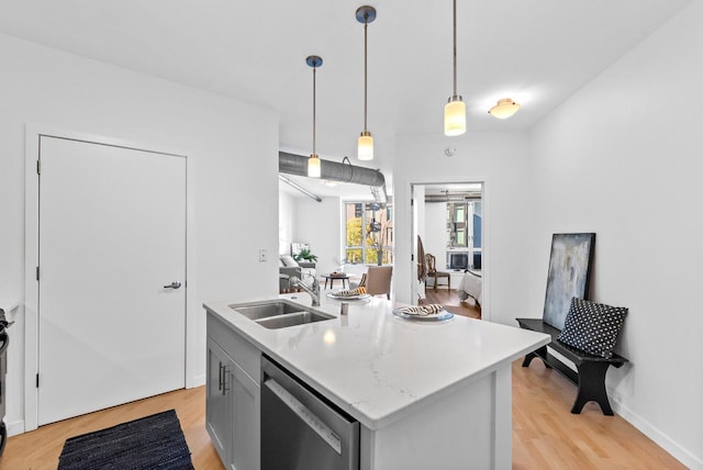 kitchen with sink, light hardwood / wood-style flooring, stainless steel dishwasher, an island with sink, and decorative light fixtures