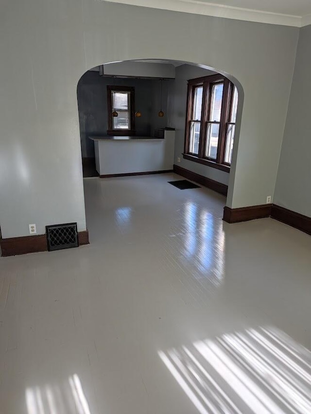 unfurnished living room featuring ornamental molding