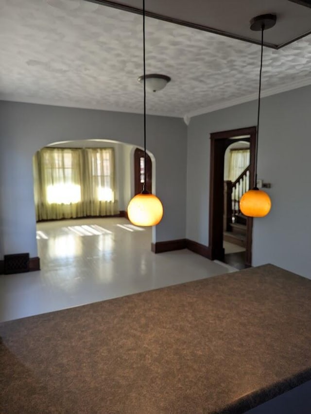 unfurnished dining area featuring a textured ceiling and concrete floors