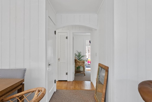 corridor featuring ornamental molding and light carpet