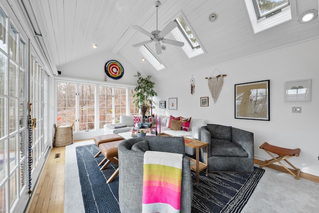 living room with a skylight, ceiling fan, high vaulted ceiling, light hardwood / wood-style flooring, and wooden ceiling