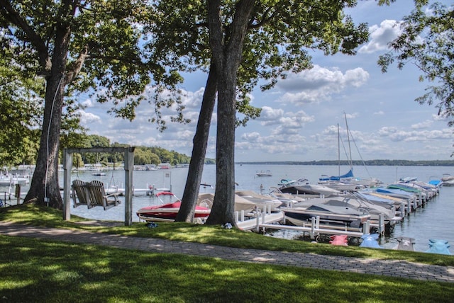 view of dock featuring a lawn and a water view