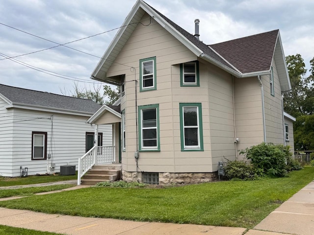 view of front of house featuring central air condition unit and a front lawn