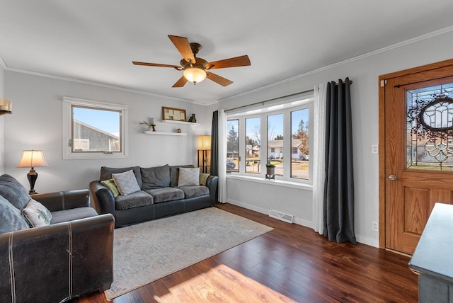 living room featuring dark hardwood / wood-style floors, ceiling fan, and crown molding