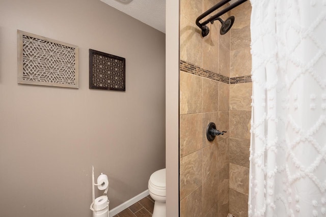 bathroom featuring curtained shower, a textured ceiling, and toilet